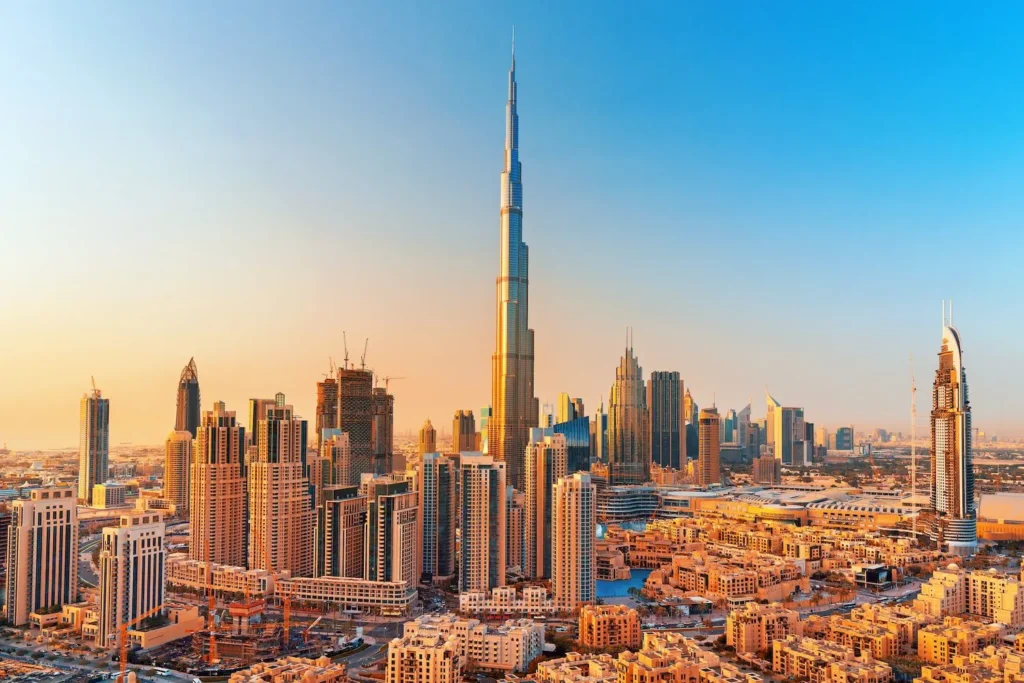 En imponerende udsigt over Dubais skyline med Burj Khalifa i centrum, oplyst af den gyldne eftermiddagssol. Billedet fremhæver den moderne arkitektur og byens høje skyskrabere, hvilket gør Dubai til en attraktiv destination for rejsende, der søger billige fly til Dubai.